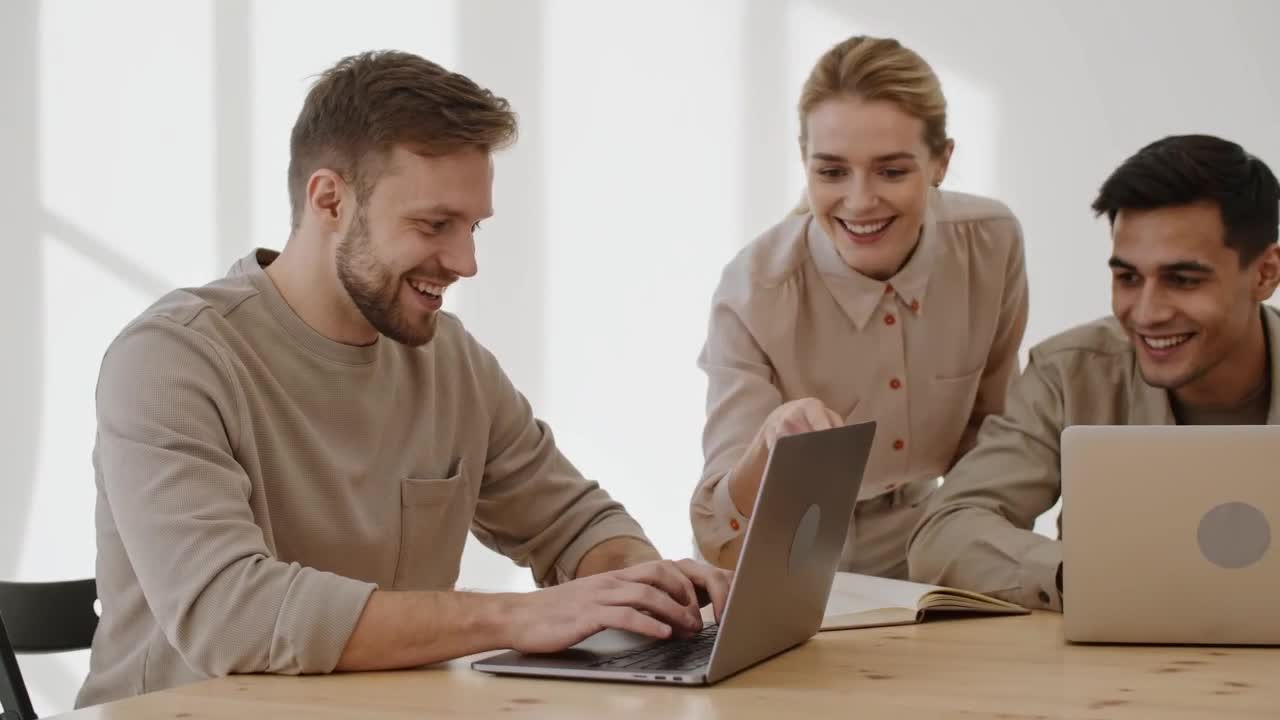 Four founders around a table with laptops, laughing as they set up email addresses on their own domain